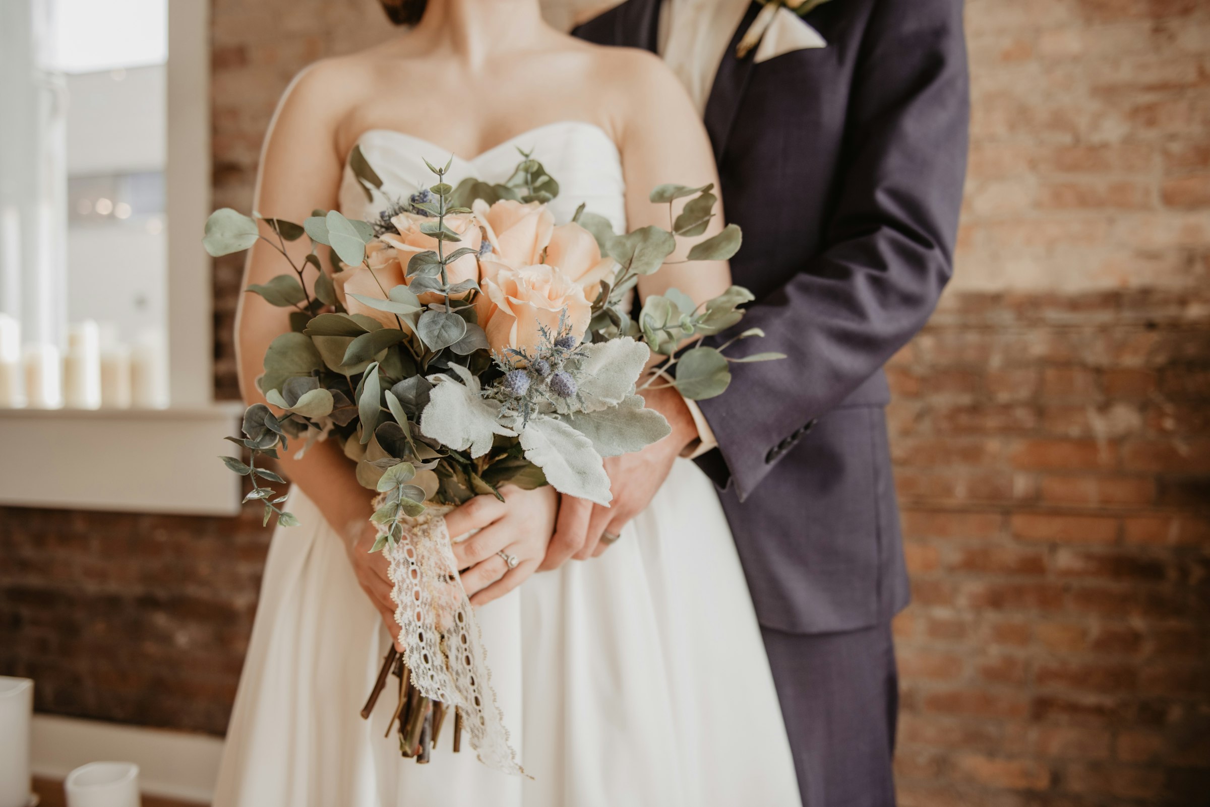 Bride and groom with a pale garden-style bouquet