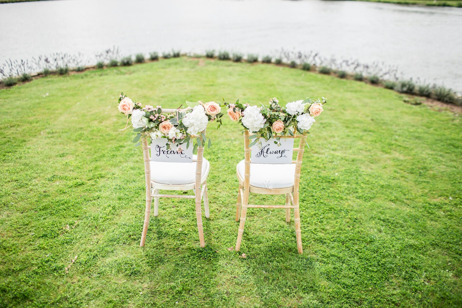 Ceremony chairs dressed with florals on a lawn